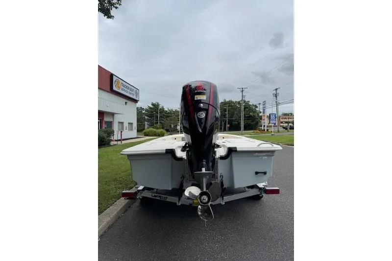 Slide: The Image of 2026 Mako 18 Pro Skiff boat with outboard motor on a trailer. - 2
