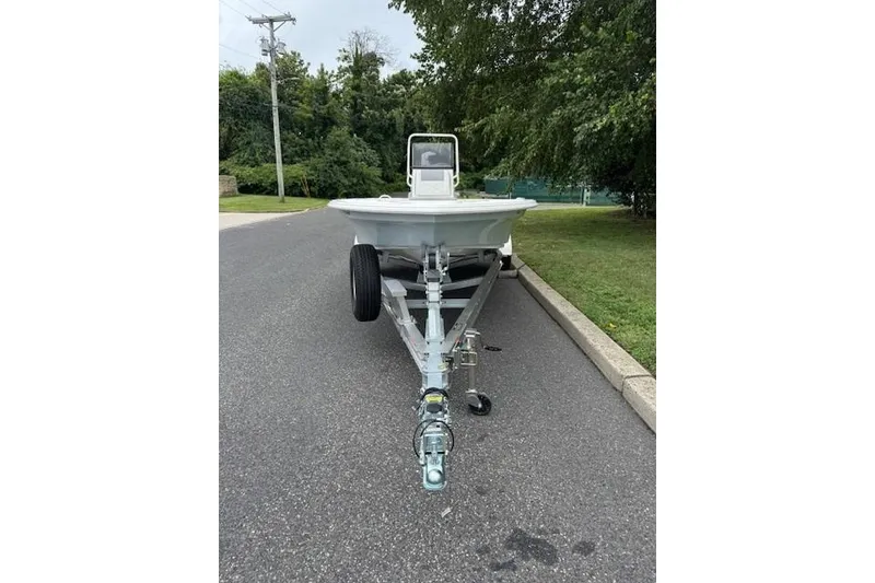 Slide: The Image of 2026 Mako 18 Pro Skiff boat on trailer, parked on a suburban street. - 3