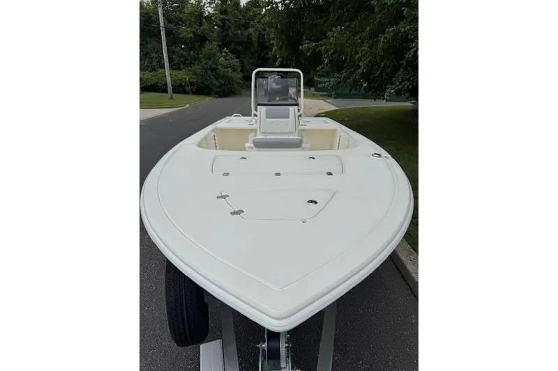 Slide: The Image of 2026 Mako 18 Pro Skiff boat on trailer, parked on a tree-lined street. - 4