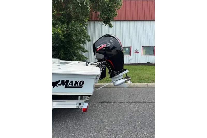 Slide: The Image of 2026 Mako 18 Pro Skiff with Mercury Pro XS outboard motor, parked outdoors. - 6