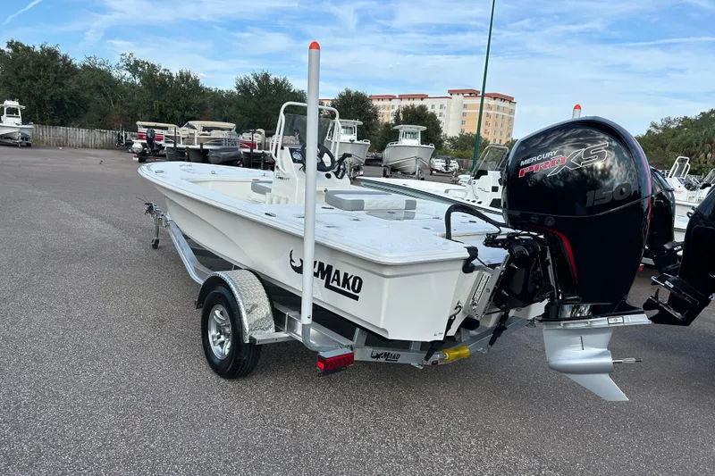 Slide: The Image of 2026 Mako 18 Pro Skiff boat with Mercury engine on trailer in parking lot. - 2