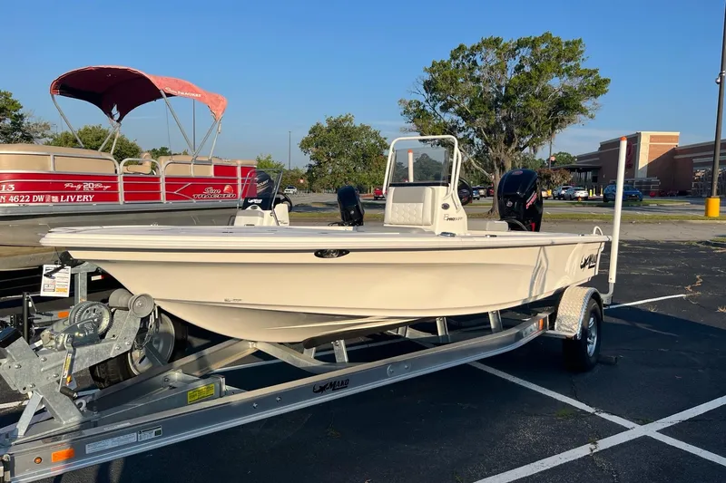 The Image of 2026 Mako 18 Pro Skiff boat on trailer in parking lot, sunny day. - 0