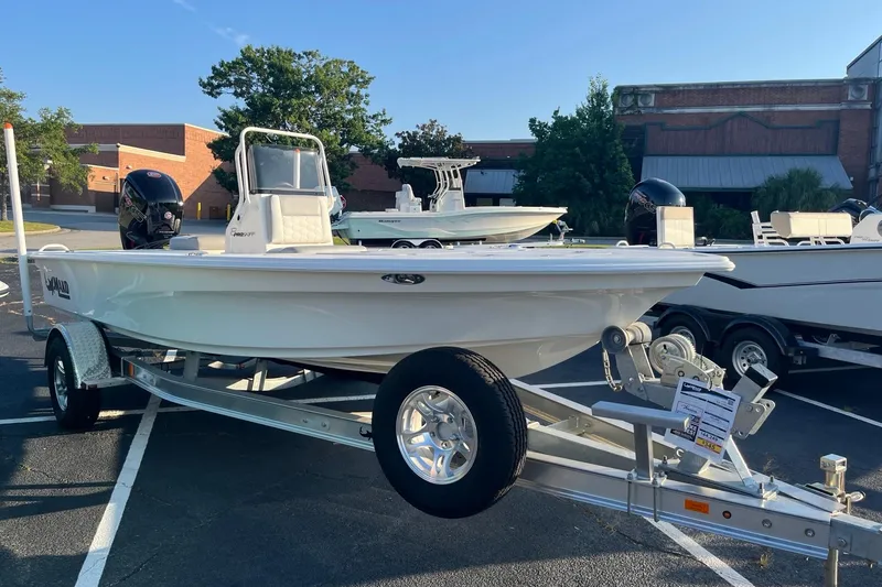 Slide: The Image of 2026 Mako 18 Pro Skiff boat on trailer in parking lot, sunny day. - 1