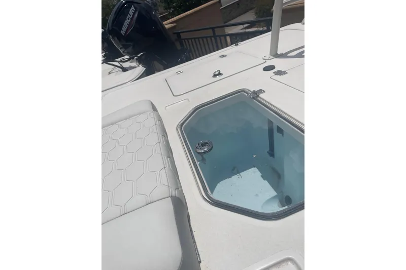 Slide: The Image of 2026 Mako 18 Pro Skiff boat deck with livewell and Mercury engine. - 12