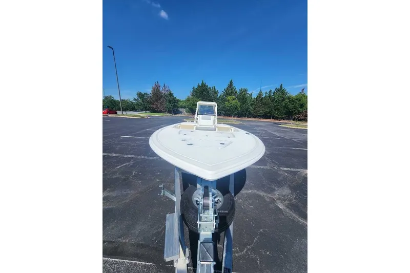 Slide: The Image of 2026 Mako 18 Pro Skiff boat on trailer in parking lot under clear blue sky. - 61