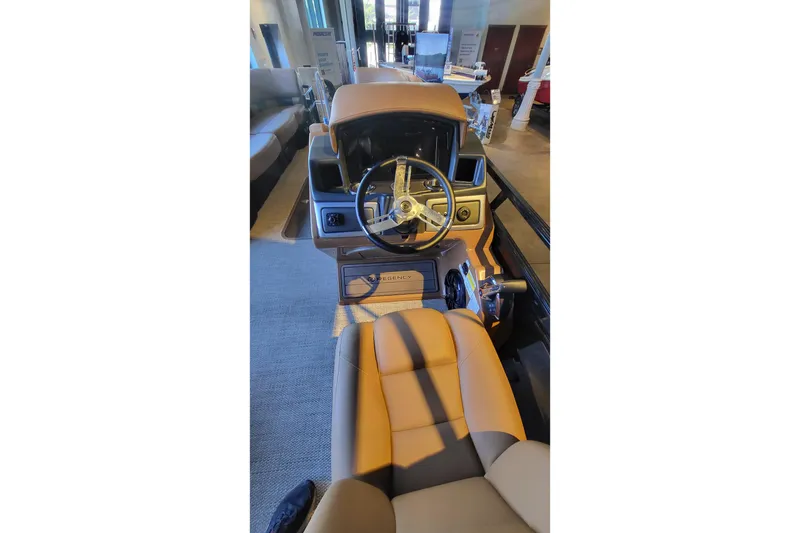 Slide: The Image of Luxurious interior of 2025 Regency 250 LE3 pontoon boat with tan seating and table. - 1