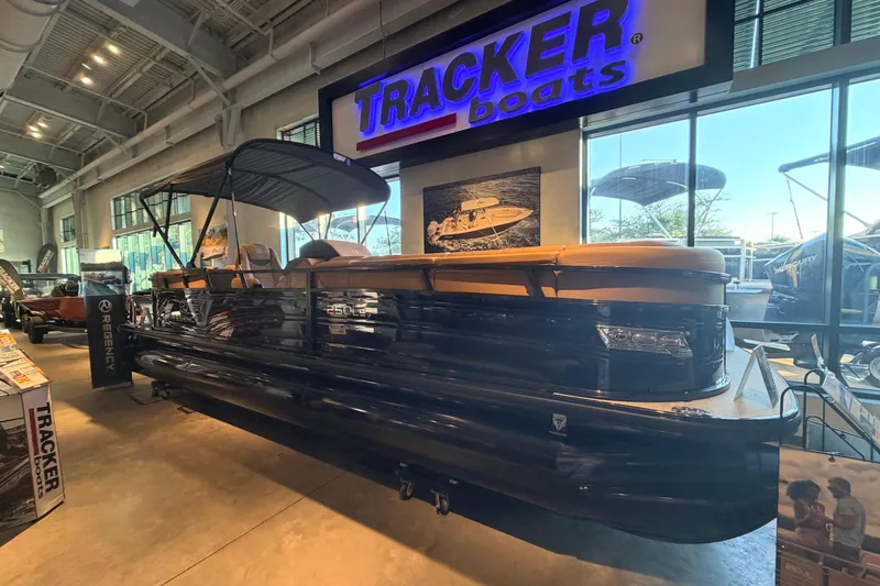 The Image of 2025 Regency 250 LE3 pontoon boat displayed in a showroom under Tracker Boats signage. - 0
