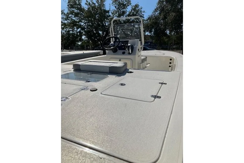 Slide: The Image of 2026 Mako 18 Pro Skiff boat interior with steering console and storage compartments. - 2