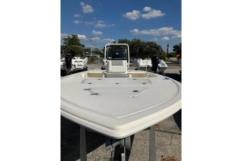 Slide: The Image of 2026 Mako 18 Pro Skiff boat, white deck, parked outdoors under blue sky. - 4