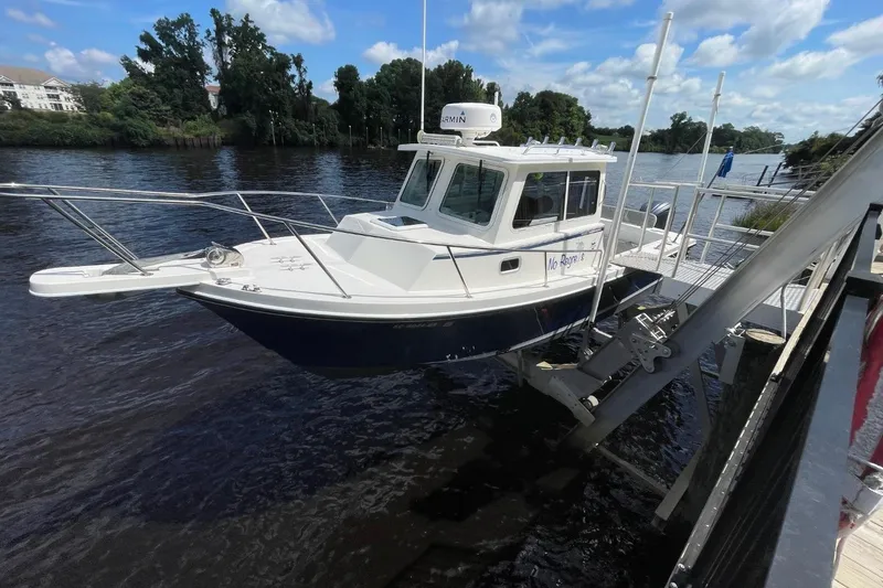 Slide: The Image of 2021 Steiger Craft 255 Chesapeake boat docked by a scenic river. - 0