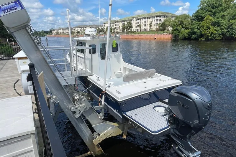 Slide: The Image of 2021 Steiger Craft 255 Chesapeake boat docked by a scenic waterfront. - 2