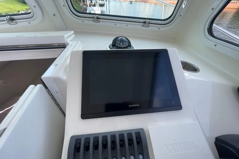 Slide: The Image of Steiger Craft 255 Chesapeake 2021 boat interior with Garmin navigation system and Yamaha controls. - 21