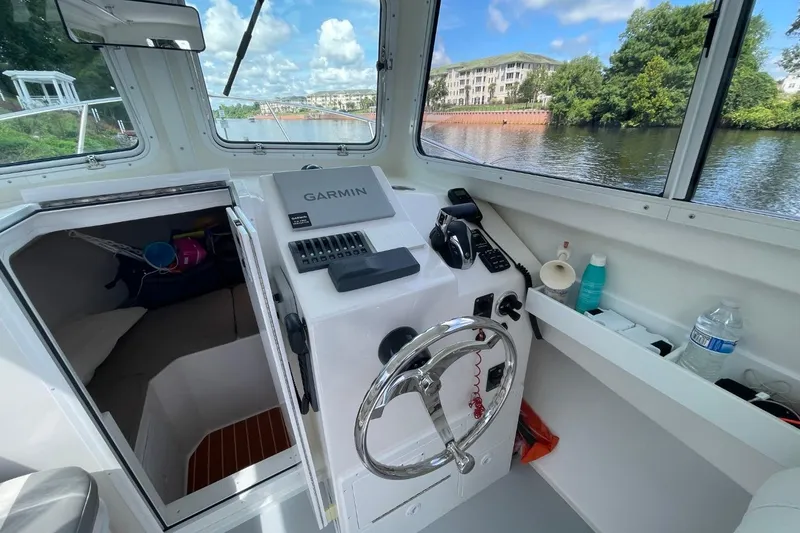 Slide: The Image of Steiger Craft 255 Chesapeake 2021 boat interior with steering wheel and navigation equipment. - 22