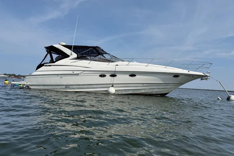 The Image of 2001 Regal Commodore 4160 yacht anchored on calm water under a clear blue sky. - 0