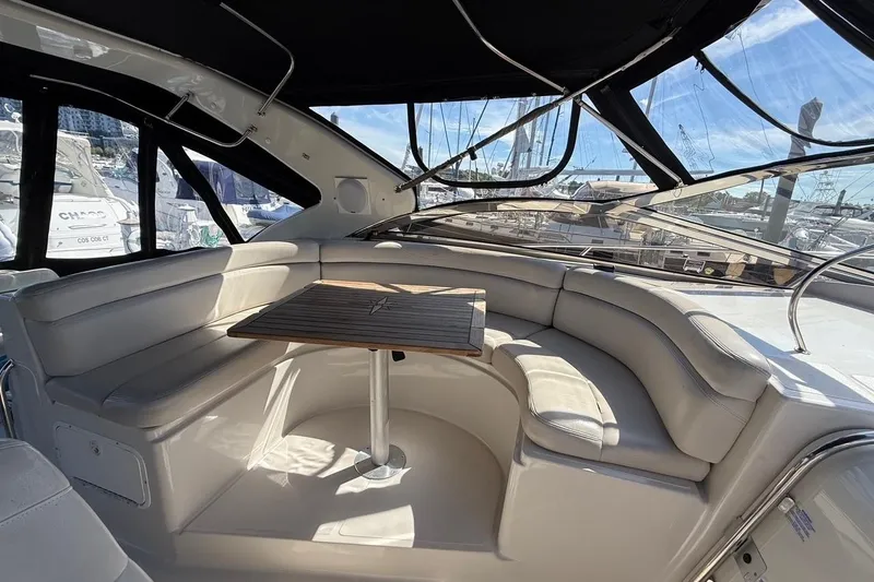 Slide: The Image of Luxurious seating area on a 2001 Regal Commodore 4160 yacht with a wooden table. - 13