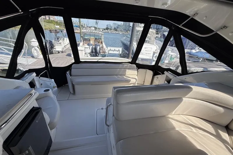 Slide: The Image of Interior of 2001 Regal Commodore 4160 yacht with white seating and marina view. - 14