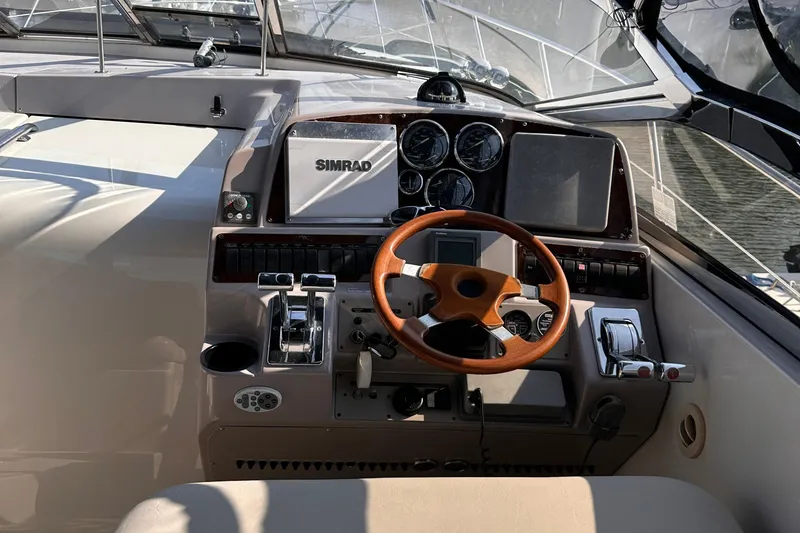 Slide: The Image of Cockpit of 2001 Regal Commodore 4160 yacht with wooden steering wheel and navigation instruments. - 5
