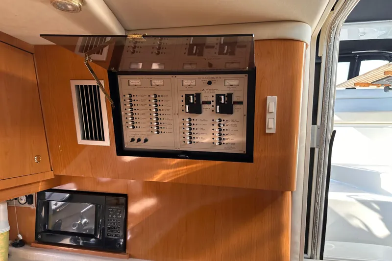Slide: The Image of Electrical control panel inside 2001 Regal Commodore 4160 yacht cabin, with microwave below. - 9