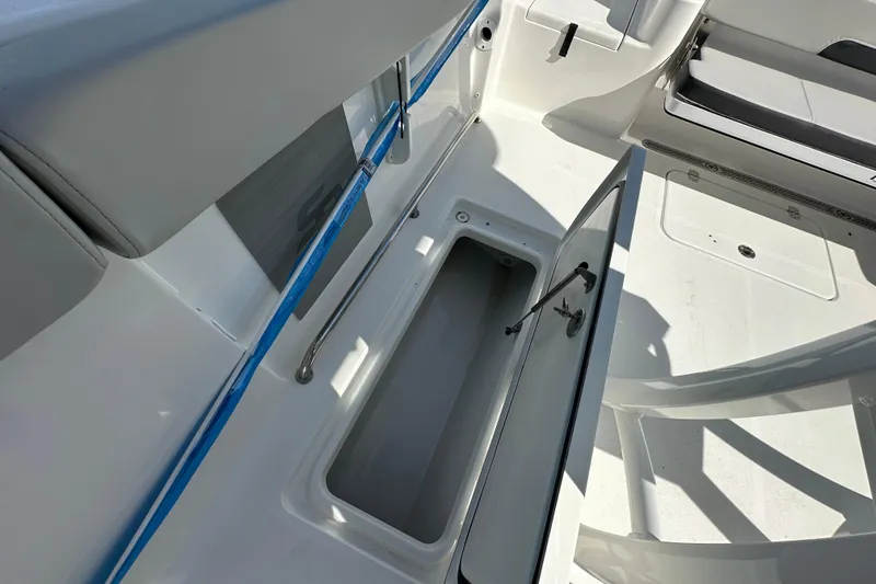 Slide: The Image of 2026 Sea Pro 262 Center Console boat storage compartment open, showcasing interior space. - 11