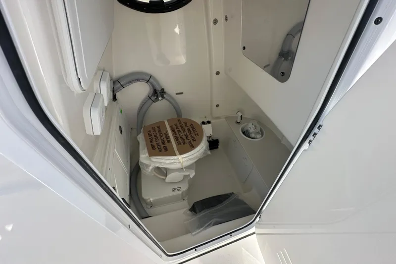 Slide: The Image of 2026 Sea Pro 262 Center Console boat interior with compact marine toilet. - 9