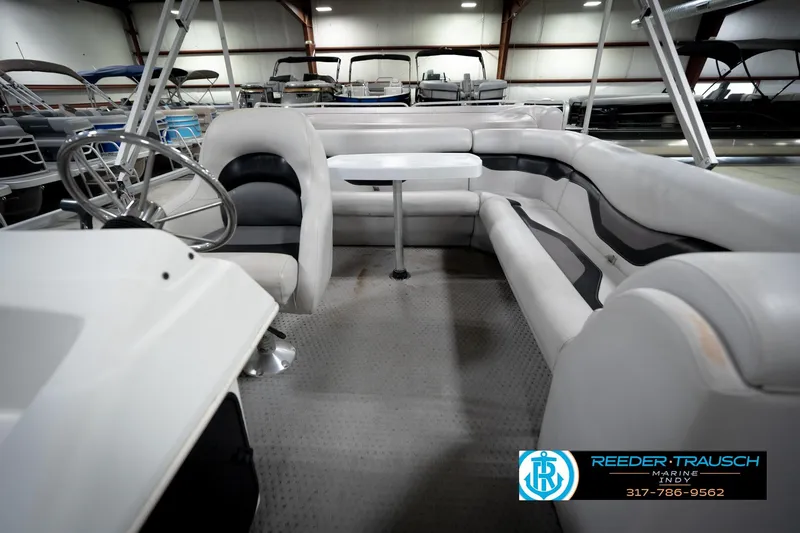 Slide: The Image of 1991 Godfrey Sanpan SP 2200 pontoon boat interior with seating, displayed indoors at Reeder-Trausch Marine. - 16