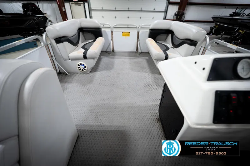 Slide: The Image of Interior of a 1991 Godfrey Sanpan SP 2200 boat with white seating and steering console. - 19