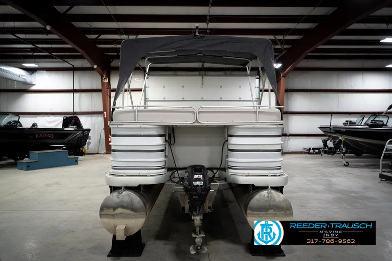 Slide: The Image of 1991 Godfrey Sanpan SP 2200 pontoon boat in indoor storage, featuring Suzuki outboard motor. - 8