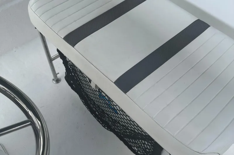 Slide: The Image of 2010 Carolina Skiff JVX16CC boat seat with white upholstery and black netting. - 6