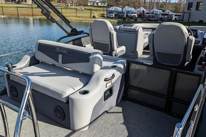 Slide: The Image of 2024 Barletta Cabrio 20UC pontoon boat interior with gray seating and lake view. - 4