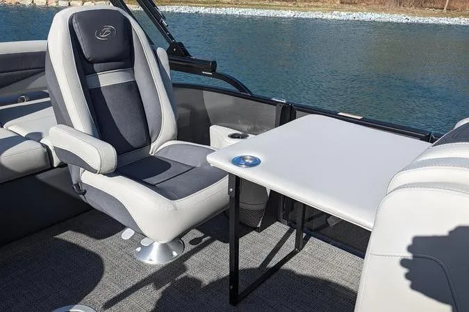 Slide: The Image of 2024 Barletta Cabrio 20UC boat interior with seating and table by the water. - 7