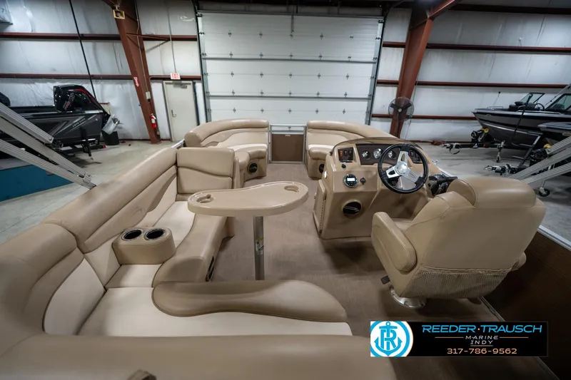 Slide: The Image of 2017 Bennington 18 SLX pontoon boat interior with beige seating and steering console. - 18