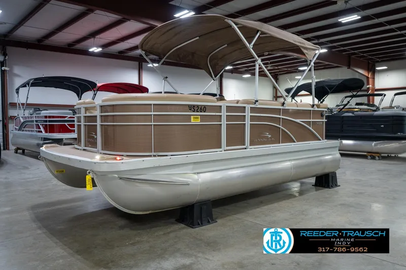 Slide: The Image of 2017 Bennington 18 SLX pontoon boat in showroom, featuring tan canopy and sleek design. - 3