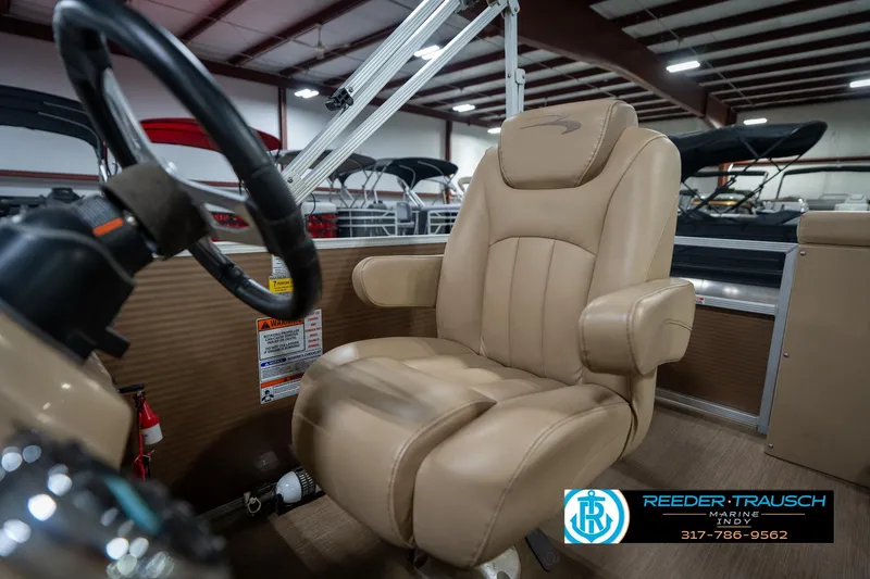 Slide: The Image of 2017 Bennington 18 SLX boat interior with tan captain's chair and steering wheel. - 38