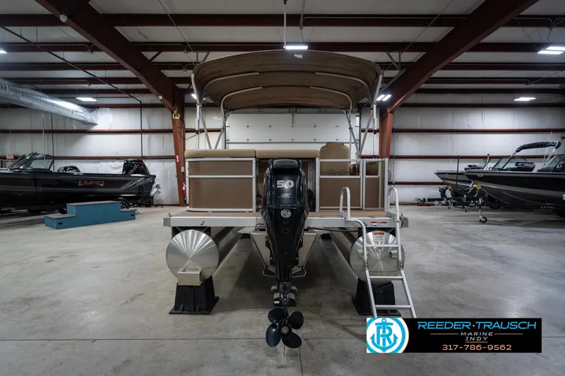 Slide: The Image of 2017 Bennington 18 SLX pontoon boat in a showroom with outboard motor. - 8