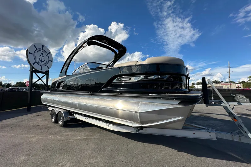 Slide: The Image of 2024 Tahoe Pontoon Grand Tahoe Elite Windshield 27' on trailer under blue sky. - 0