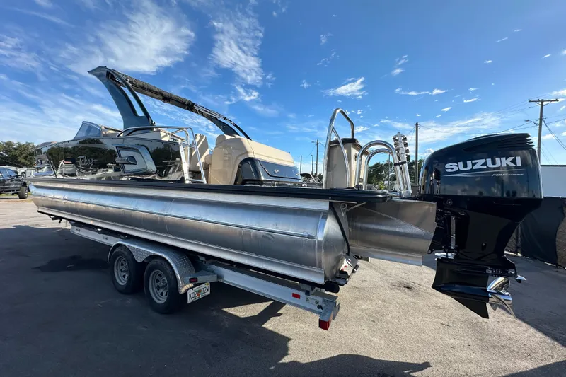 Slide: The Image of 2024 Tahoe Pontoon Grand Tahoe Elite Windshield 27' with Suzuki outboard motor on trailer. - 8