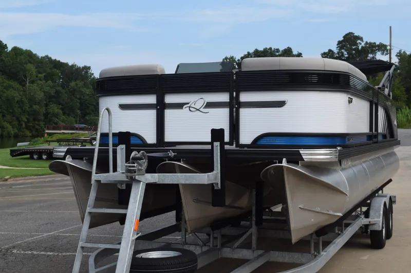 Slide: The Image of 2025 Qwest L-Class 822 RLS pontoon boat on trailer, parked near a lake. - 3