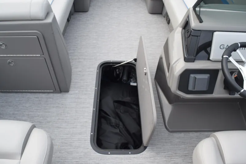 Slide: The Image of 2025 Qwest L-Class 822 RLS boat interior with open storage compartment and steering console. - 34