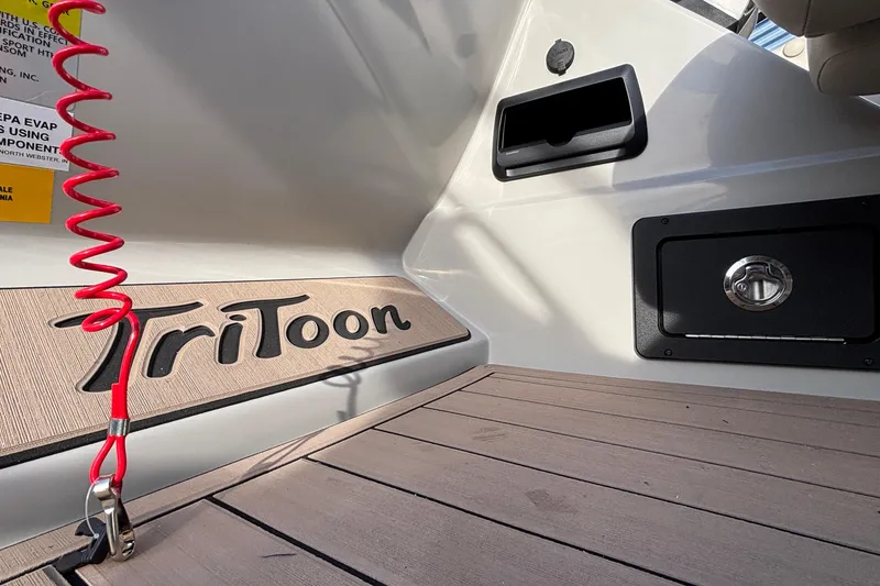 Slide: The Image of Interior of 2026 JC Neptoon 25TT Sport boat with Tritoon branding and red safety cord. - 33
