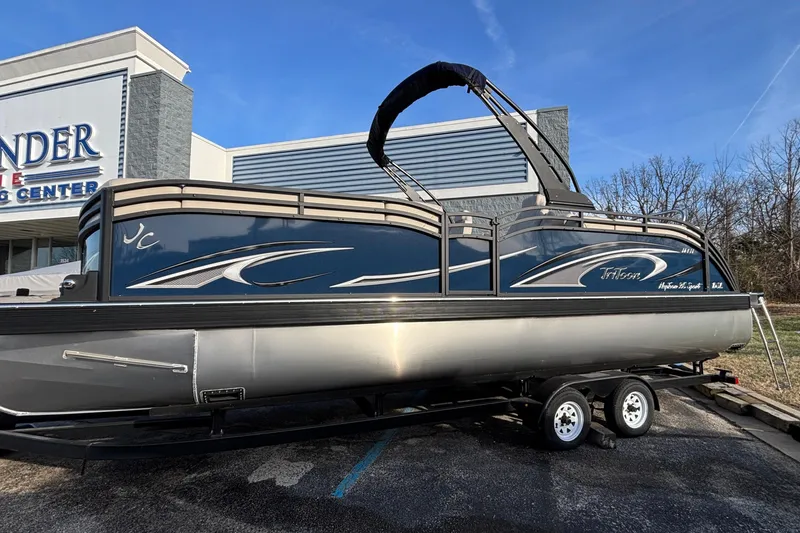 The Image of 2026 JC Neptoon 25TT Sport pontoon boat on trailer outside dealership. - 2