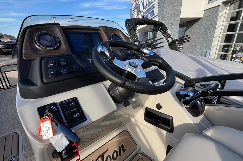 Slide: The Image of 2026 JC Neptoon 25TT Sport boat dashboard with steering wheel and controls. - 21