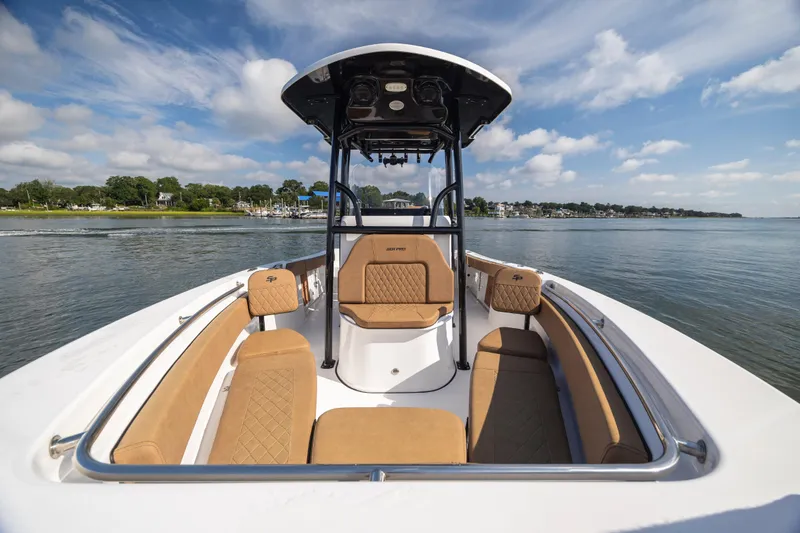 Slide: The Image of 2023 Sea Pro 219 Deep V CC boat on calm water, featuring tan seating and sleek design. - 10