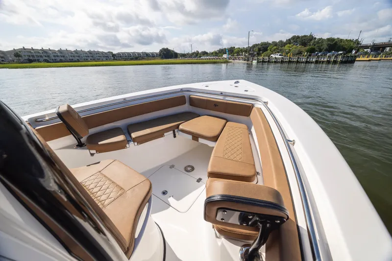 Slide: The Image of 2023 Sea Pro 219 Deep V CC boat interior with tan seating on calm water. - 14