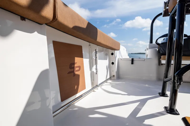 Slide: The Image of 2023 Sea Pro 219 Deep V CC boat interior with brown seating and logo detail. - 16