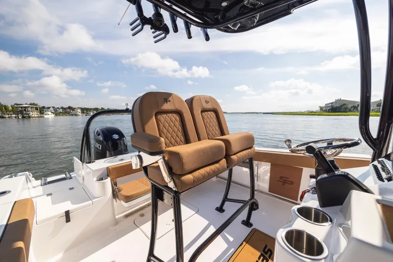 Slide: The Image of 2023 Sea Pro 219 Deep V CC boat interior with tan seating and scenic water view. - 17
