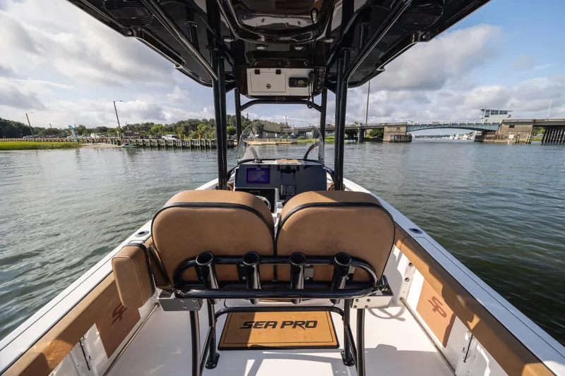 Slide: The Image of 2023 Sea Pro 219 Deep V CC boat interior with dual seats, navigating a scenic waterway. - 21