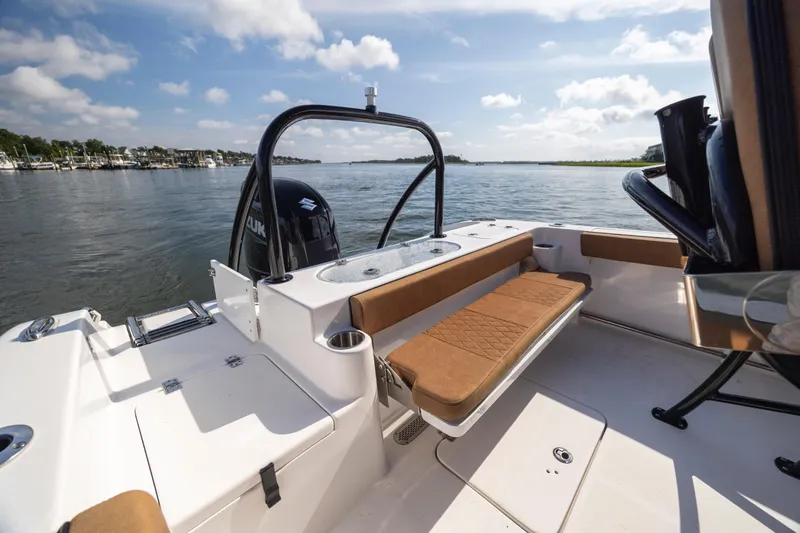 Slide: The Image of 2023 Sea Pro 219 Deep V CC boat interior with seating, on a calm waterway. - 25