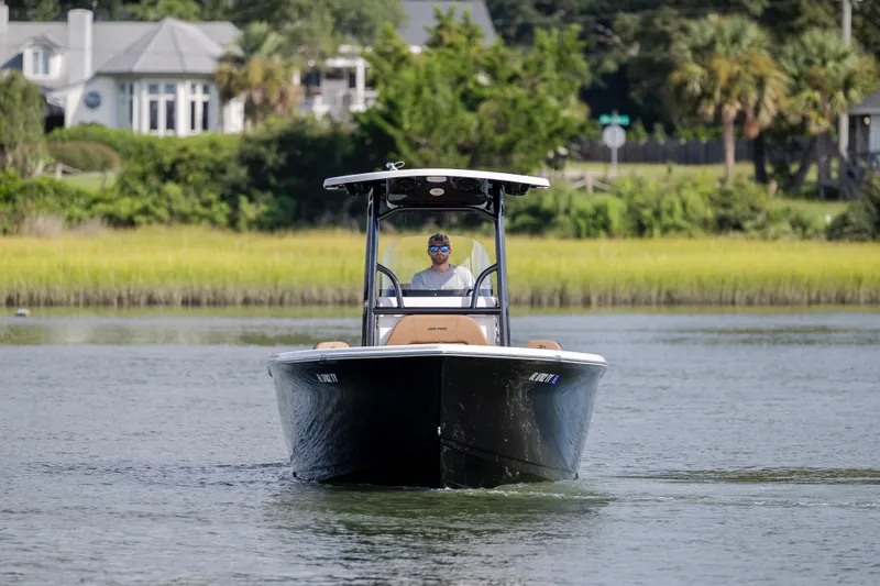 Slide: The Image of 2023 Sea Pro 219 Deep V CC boat cruising on a calm waterway with lush greenery. - 4