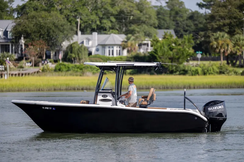 Slide: The Image of 2023 Sea Pro 219 Deep V CC boat cruising on a calm river with lush greenery. - 6