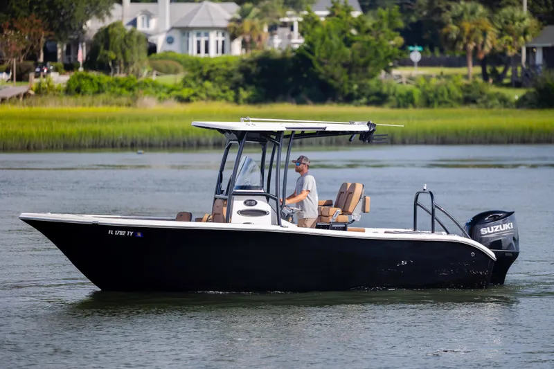 Slide: The Image of 2023 Sea Pro 219 Deep V CC boat cruising on a calm river with lush greenery. - 7